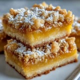 A close-up of Homemade Lemon Crumb Bars revealing a bright yellow, tangy lemon filling and buttery crumble.