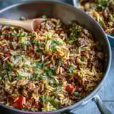 Spoonful of savory Comforting Ground Beef Orzo Dinner featuring bell peppers, peas, and herbs.