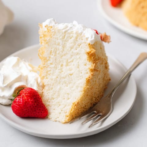 Perfectly risen Angel Food Cake with fresh berries, ready for serving.