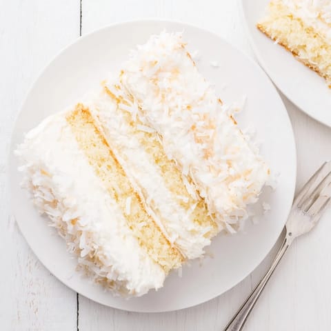 Three layers of tender Coconut Cake with luscious filling, frosted with billowy meringue and coconut flakes.