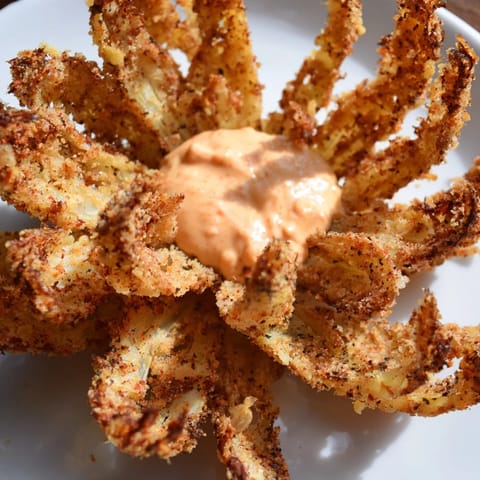 Crispy, golden-brown Onion Petals with Spicy Dipping Sauce on a rustic wooden platter, steaming hot and ready to share.