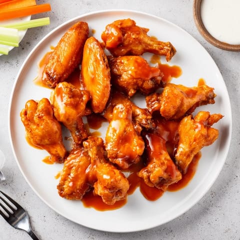 Freshly tossed Honey BBQ Chicken Wings glistening in rich sauce, ready for game day appetizers or parties.