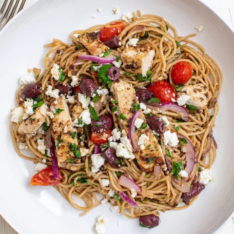 Fresh parsley, red onion, and a zesty lemon dressing brighten this hearty Greek Chicken Spaghetti, served steaming and ready for dinner.