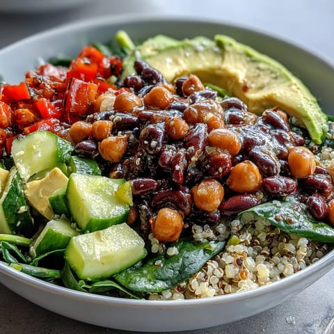 Vibrant Three-Bean Power Bowl with quinoa, fresh diced veggies, avocado slices, and a zesty lemon-herb dressing.  