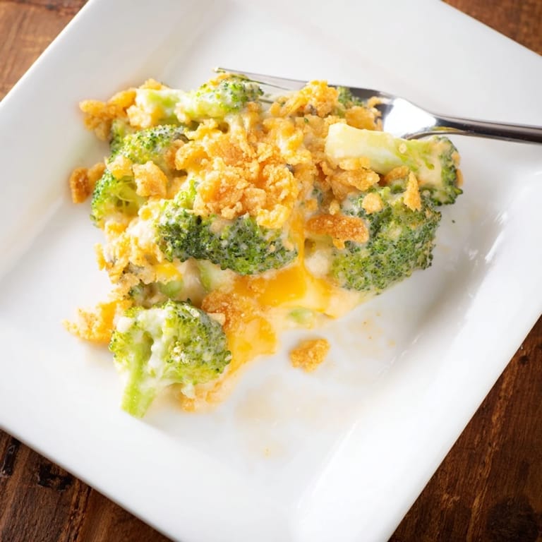 A freshly baked broccoli casserole with a bubbling cheddar sauce and buttery cracker topping, ready to serve at a family dinner.