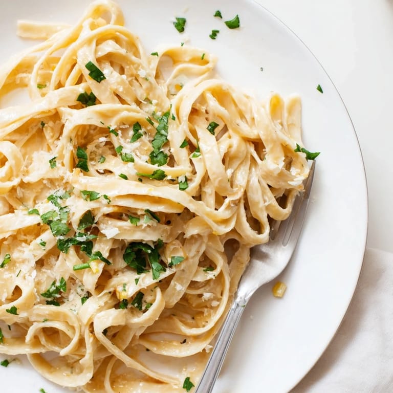 Platter of Sriracha Honey Pasta topped with parsley and parmesan, with garlic and honey notes highlighted for serving.
