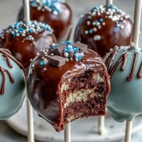 Festive graduation cake pops in school colors, dipped in chocolate and topped with edible glitter.  