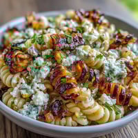 A vibrant bowl of Elote Corn Pasta with Cotija, showcasing sweet charred corn, creamy dressing, and fresh herbs.
